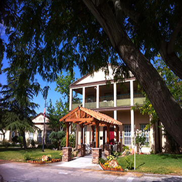 Lancaster Estates Image, trees over a wooden covered entrance with grassy lawn